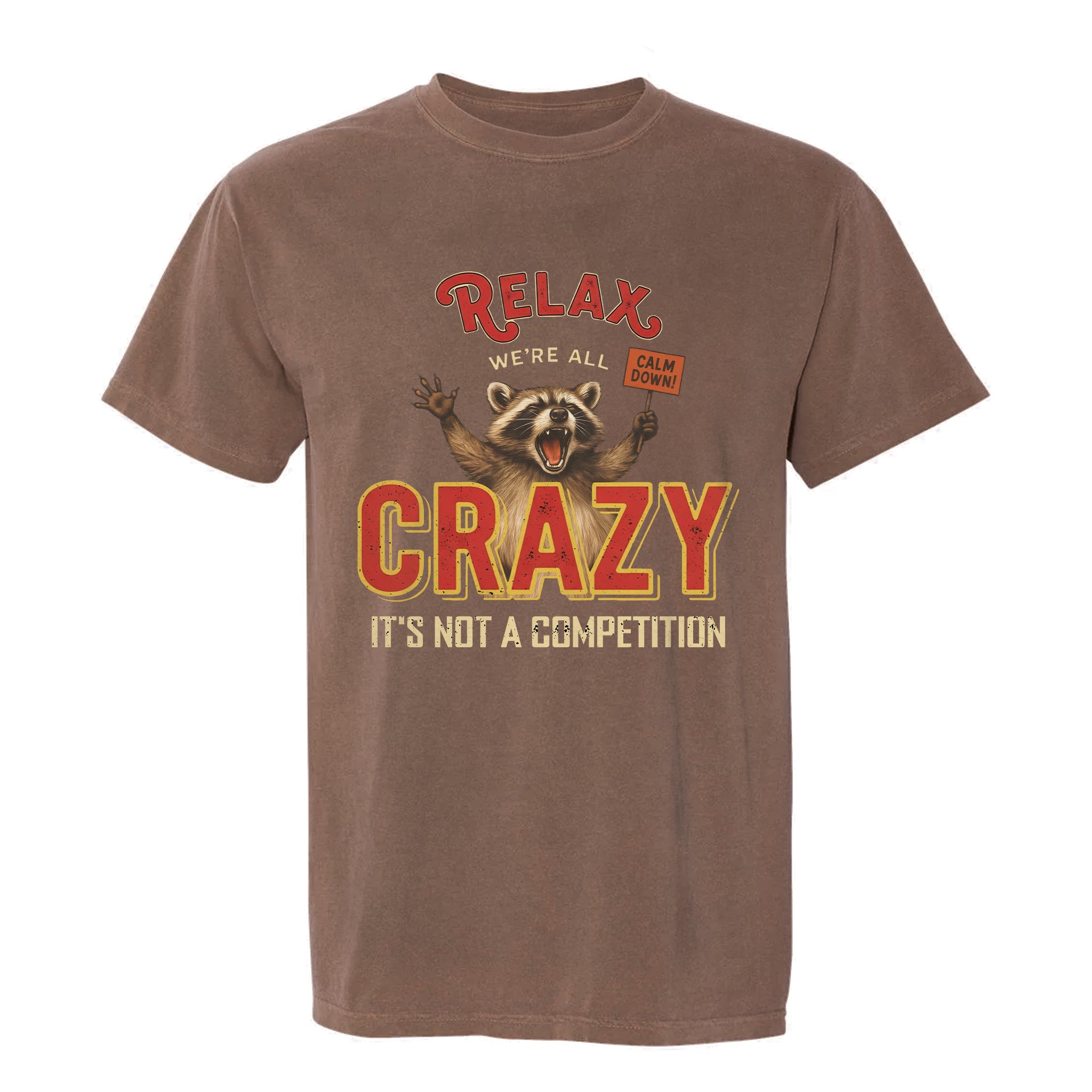Brown funny graphic t-shirt with a graphic of a raccoon and text "Relax We're All Crazy It's Not A Competition"