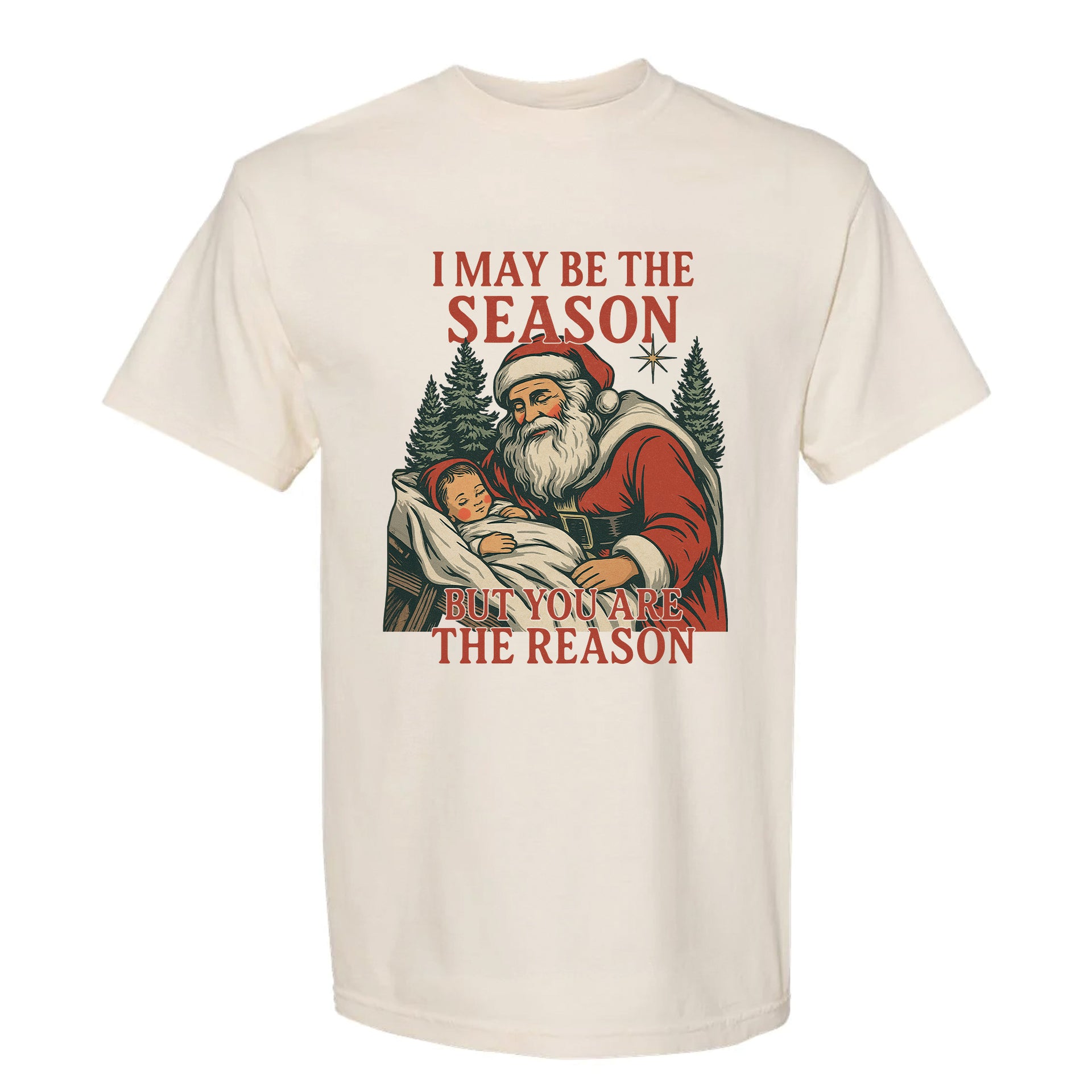 Beige Christmas graphic t-shirt with Santa holding baby Jesus and text ‘I May Be the Season But You Are the Reason’.